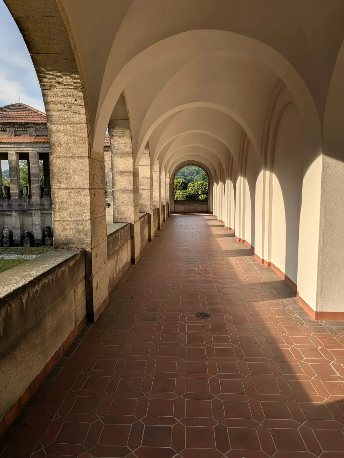 Galerie à arcades, sol carrelé de terre cuite rayé d’ombres et de soleil