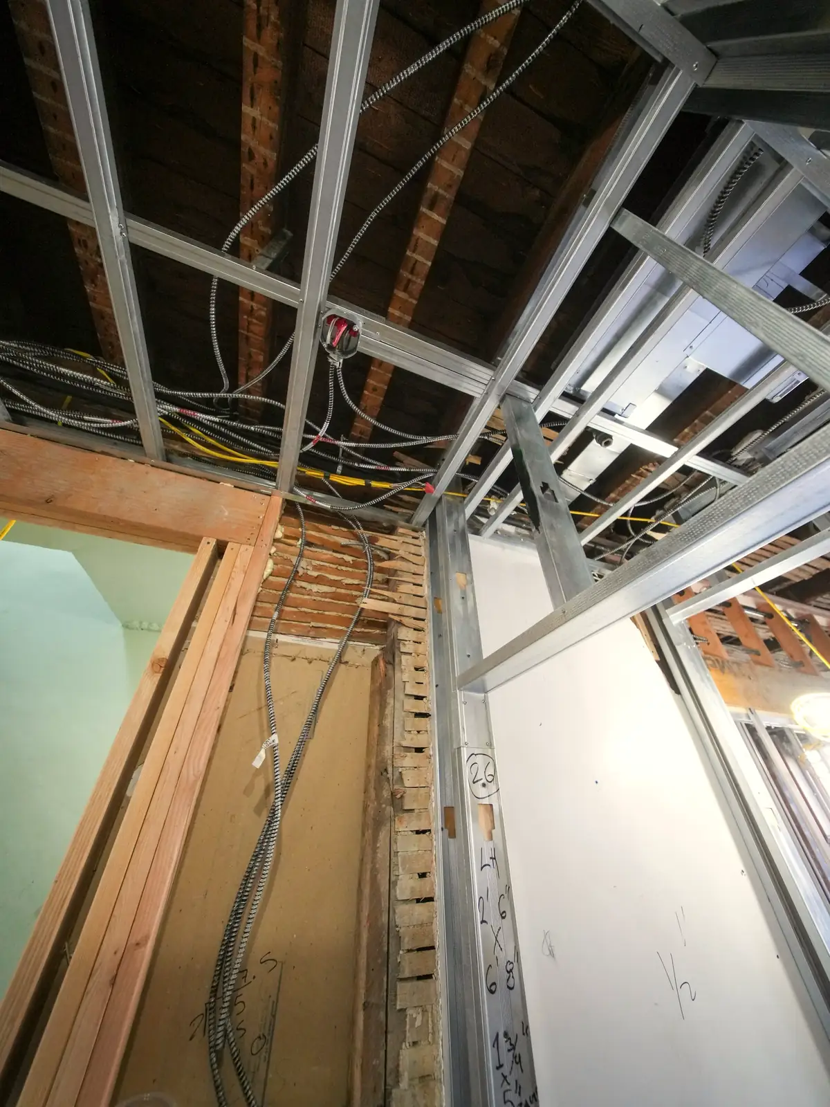Ossature métallique de faux plafond posée, gaines électriques en attente
