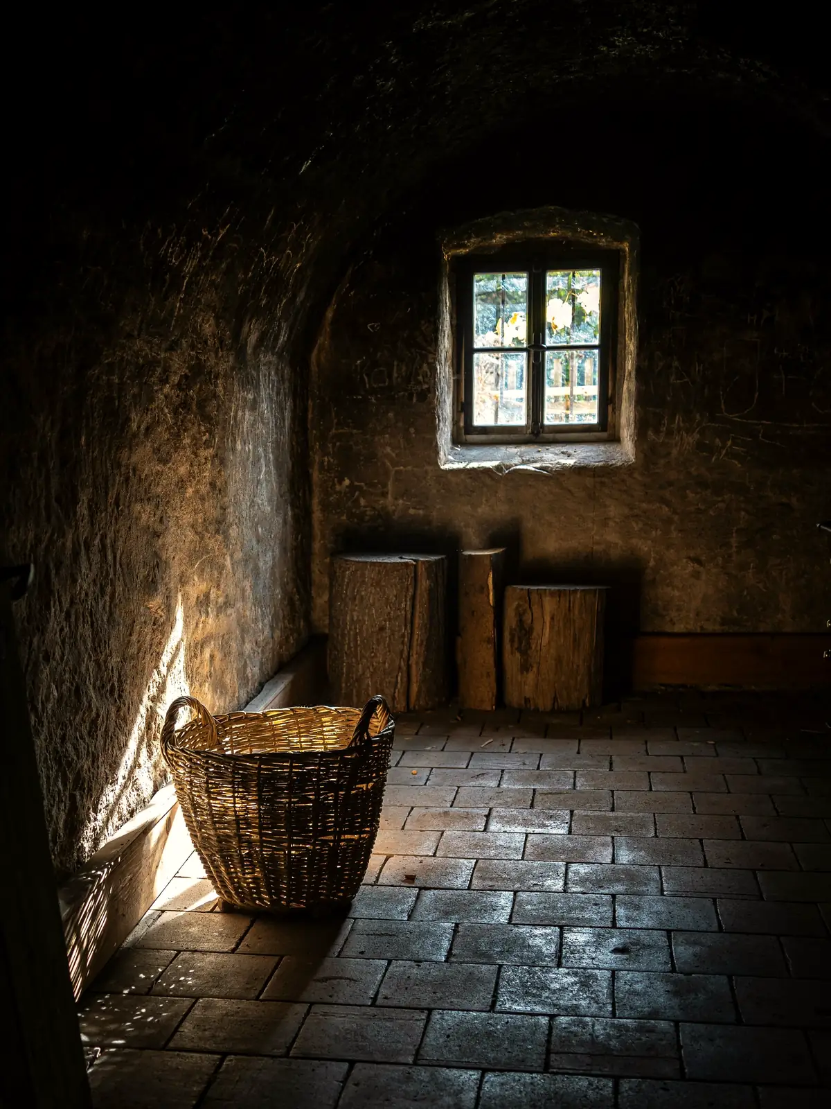 Pièce ancienne aux murs de pierre, sol de tomettes et petite fenêtre