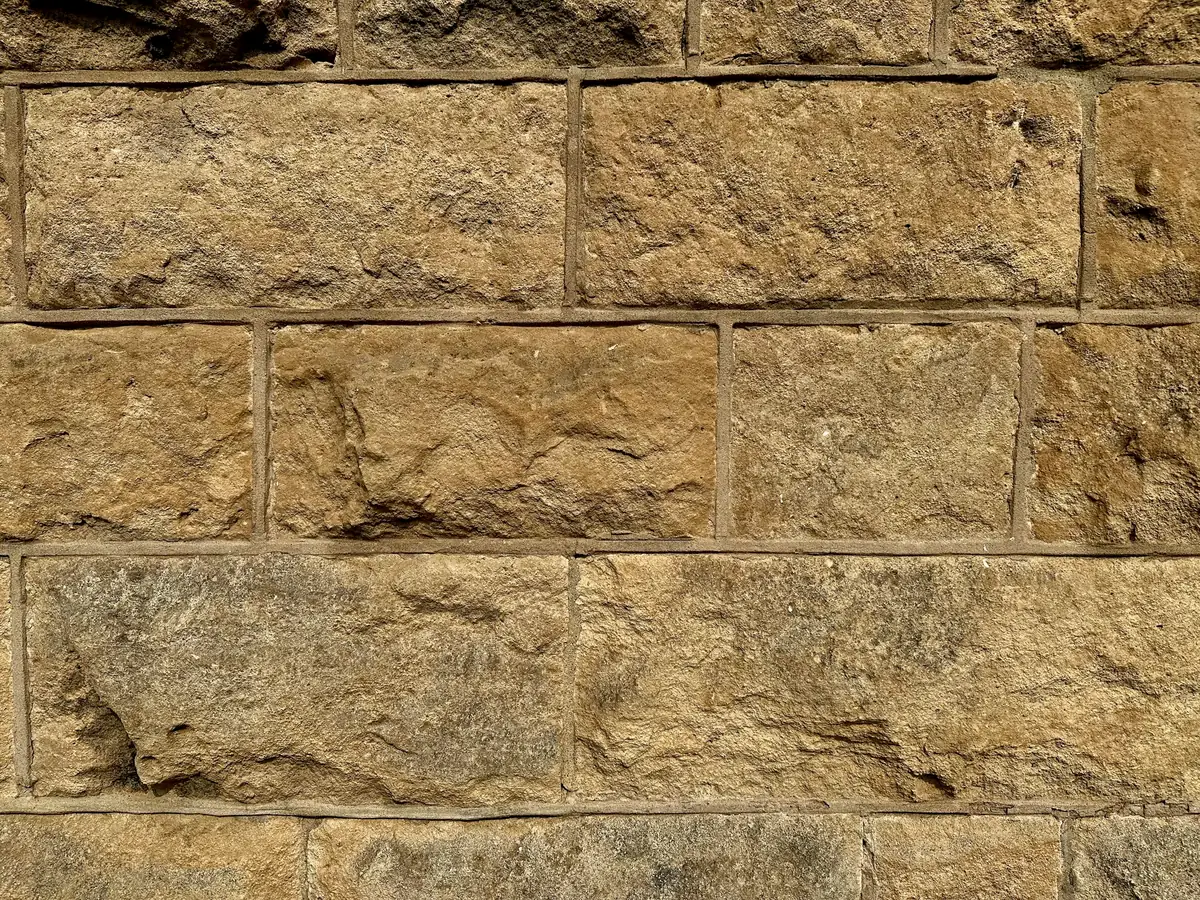 Mur de pierres de taille calcaires, faces bouchardées et joints creusés