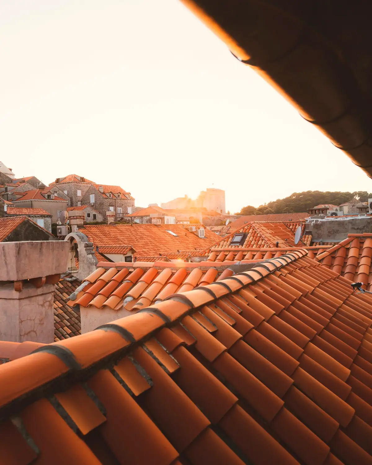 Toits de tuiles d’une vieille ville dans la lumière du soir